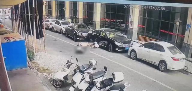 骑车女子街道上突然倒地不起，被一块从天而降的红砖砸中